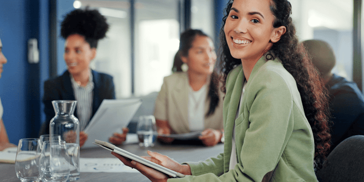 A smiling professional sitting at a conference table. 